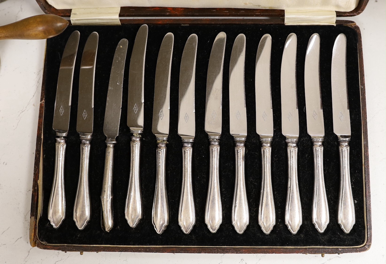 A case of twelve silver handled tea knives, one damaged, Sheffield 1931, two pairs of silver plated wine coasters including 19th century, a plated cafe au lait pair and two other plated items.